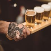 Bartender's hand holding a selection of Public House Brewing Company beers